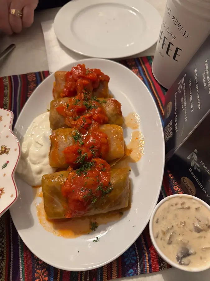 Kohlrouladen in Tomatensauce mit Sauerrahm und einer Schale Pilzsauce